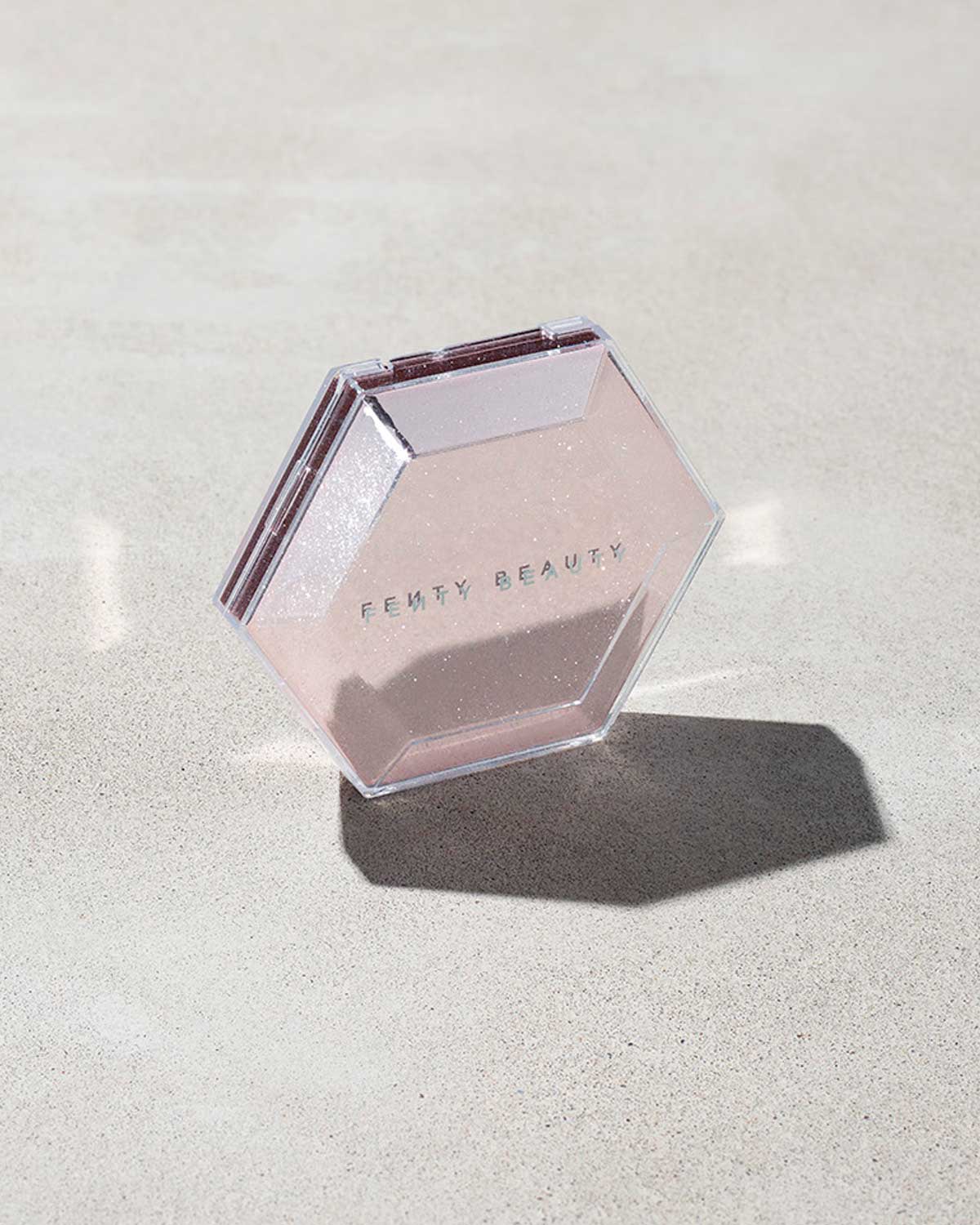  Close compact of the Diamond Bomb All-Over Highlighter on a marbled background.
