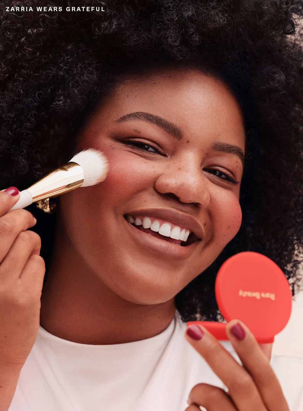 Grateful| Model Zarria wearing Rare Beauty's Soft Pinch Matte Bouncy Blush in the soft red shade Grateful.
