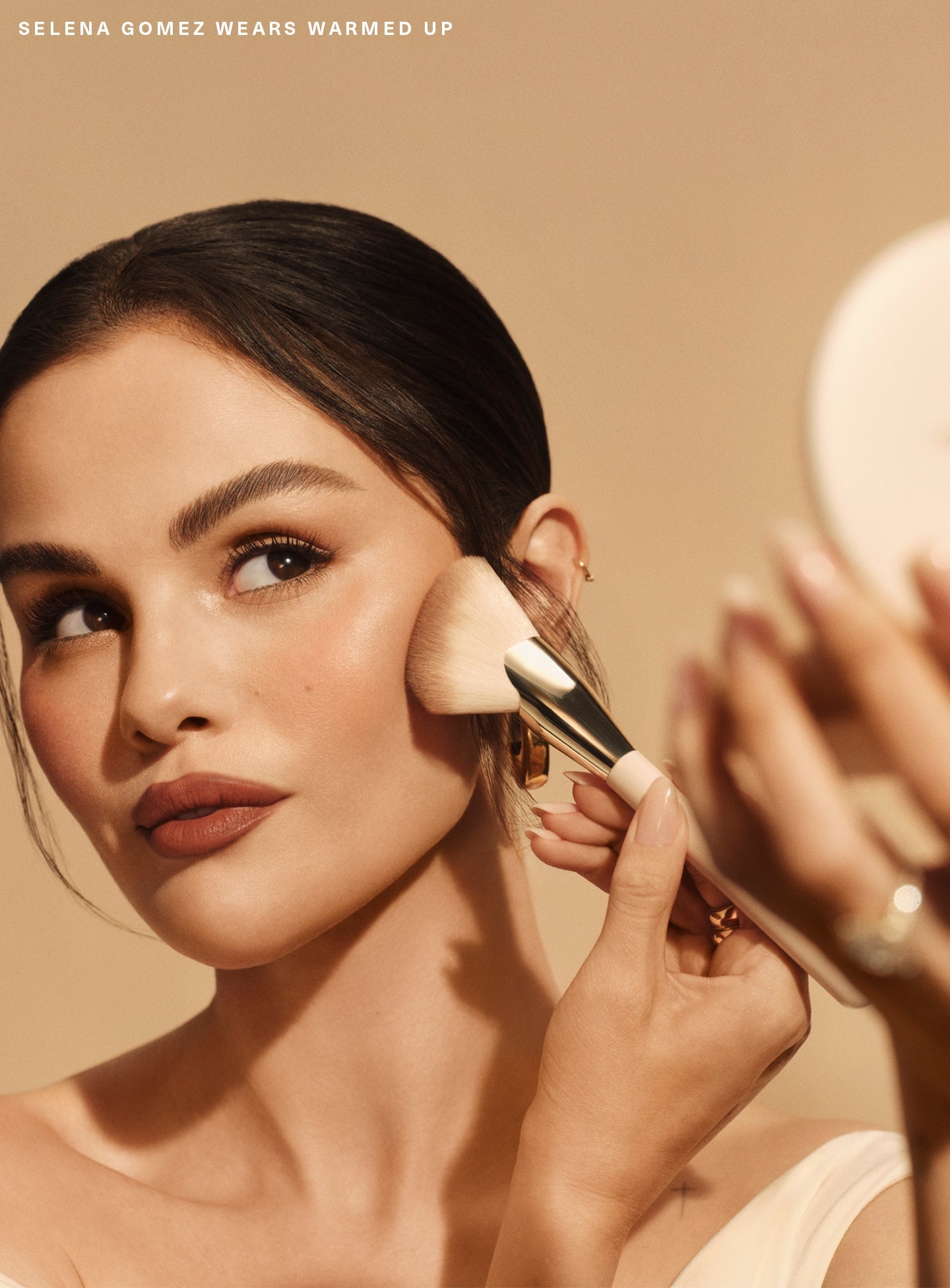 Warmed Up| Selena Gomez uses the Rare Beauty Angled Powder Brush to apply bronzer to her cheekbones