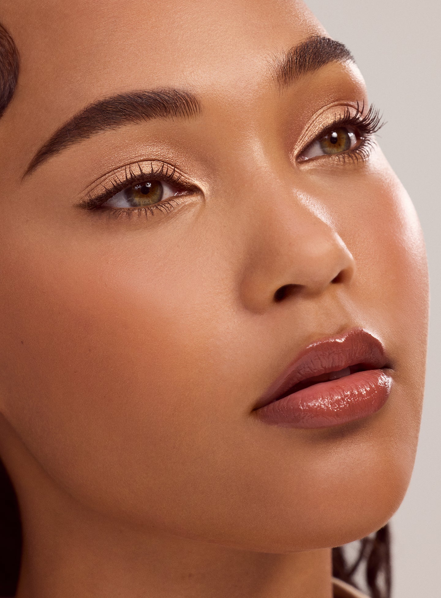 Model with light brown skin tone wearing a simple eyeshadow look using the Rare Beauty Essential Neutrals eyeshadow palette