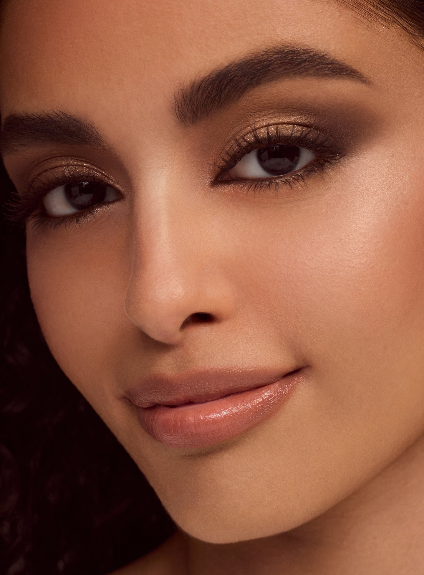 Model with olive skin tone wearing a smoky eyeshadow look using the Rare Beauty Essential Neutrals eyeshadow palette