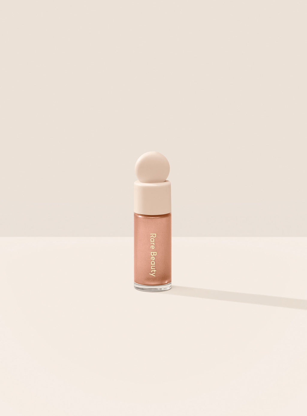 Mesmerize| Two models of different skin tones demonstrate Rare Beauty's Positive Light Liquid Luminizer in the shade Mesmerize. 
