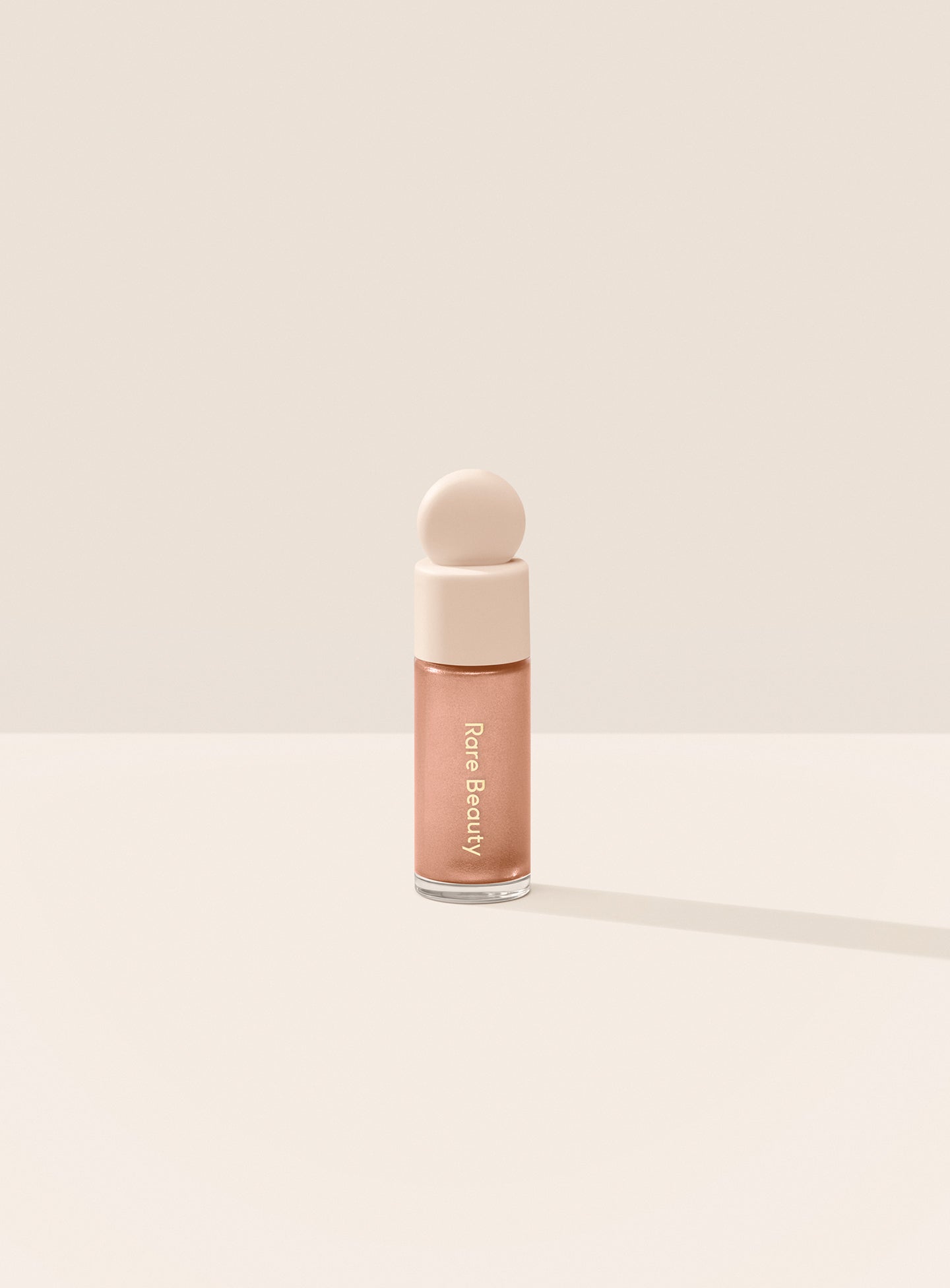 Mesmerize| Two models of different skin tones demonstrate Rare Beauty's Positive Light Liquid Luminizer in the shade Mesmerize. 