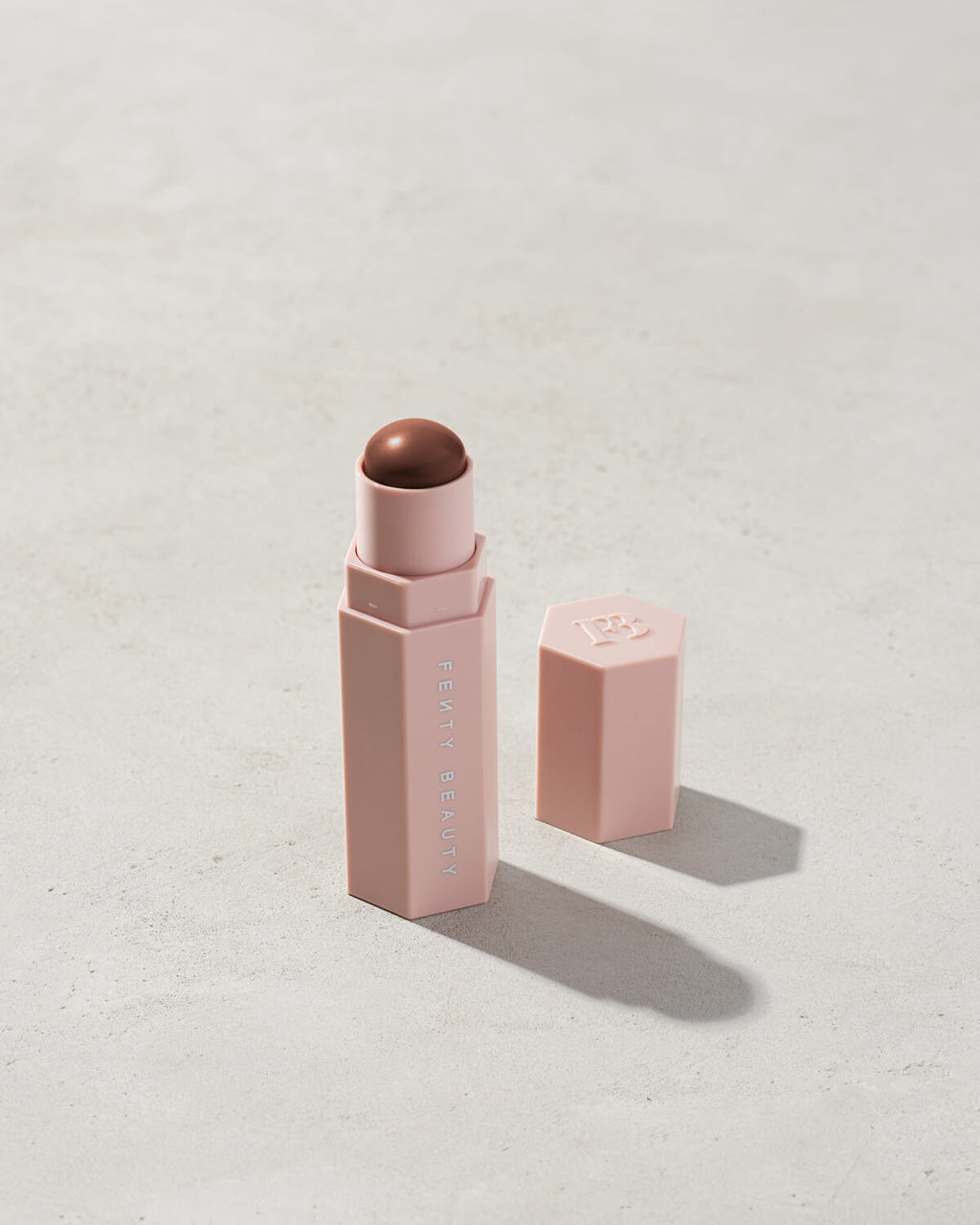 Match Stix Contour Skinstick shown in shade Espresso on a concrete background. 