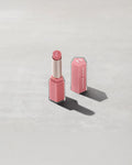 Open product shot of Gloss Bomb Stix Shimmer in shade Fussy on a concrete background.