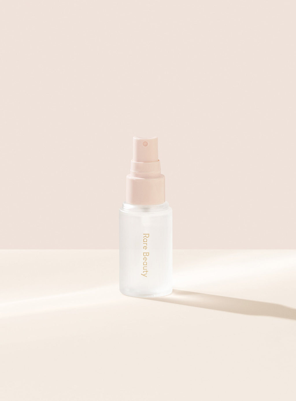 | Rare Beauty's Always an Optimist 4-In-1 Mist Mini with the cap off, designed to hydrate, prime, set, and refresh skin. 