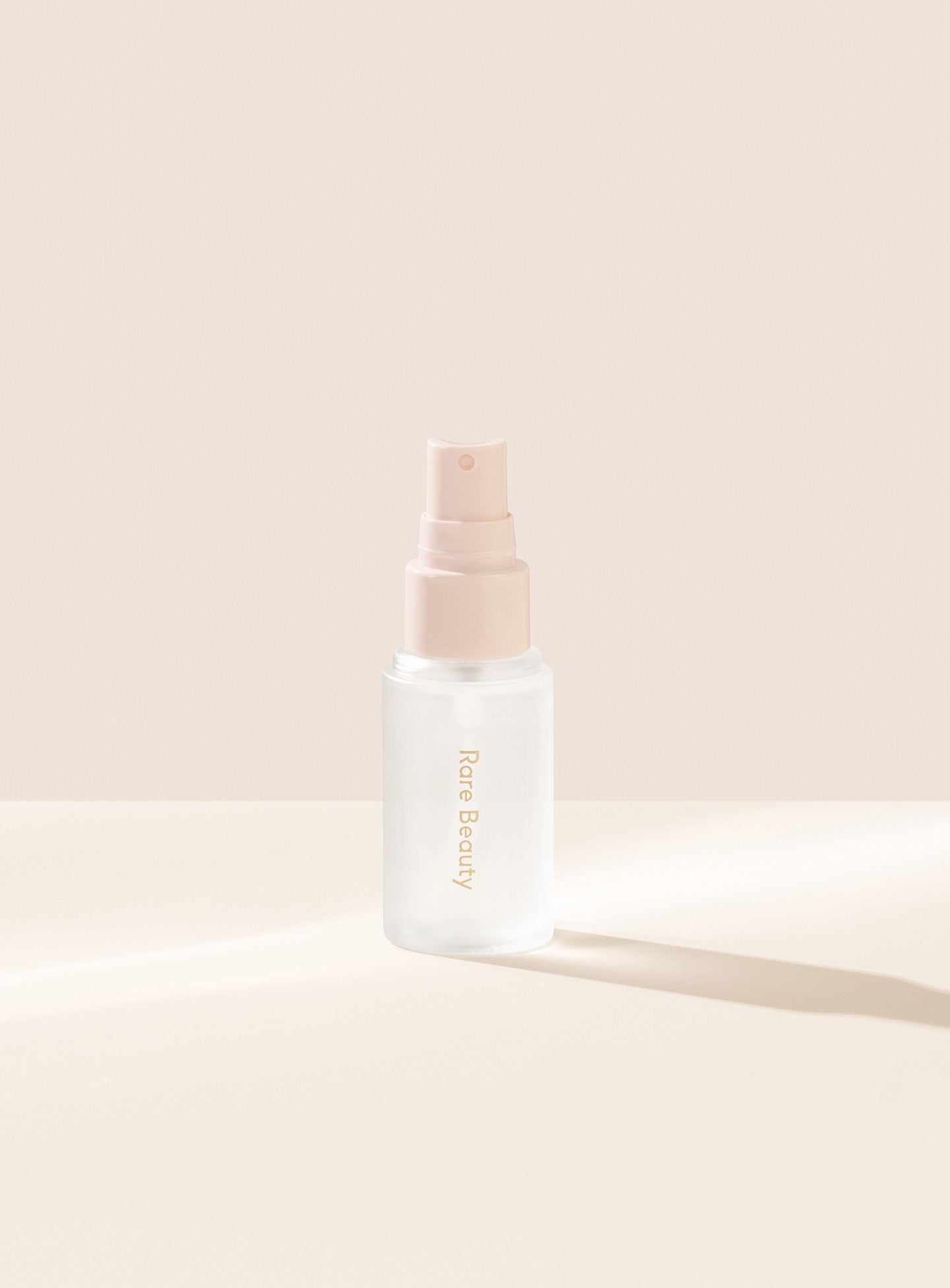 | Rare Beauty's Always an Optimist 4-In-1 Mist Mini with the cap off, designed to hydrate, prime, set, and refresh skin. 