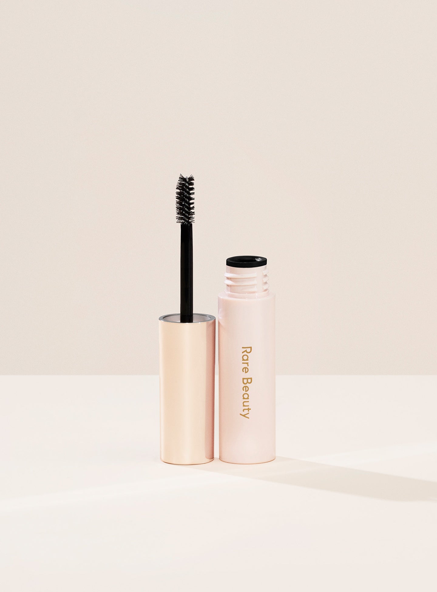 Clear| A tube of Rare Beauty's Brow Harmony Flexible Lifting Gel and its brush.