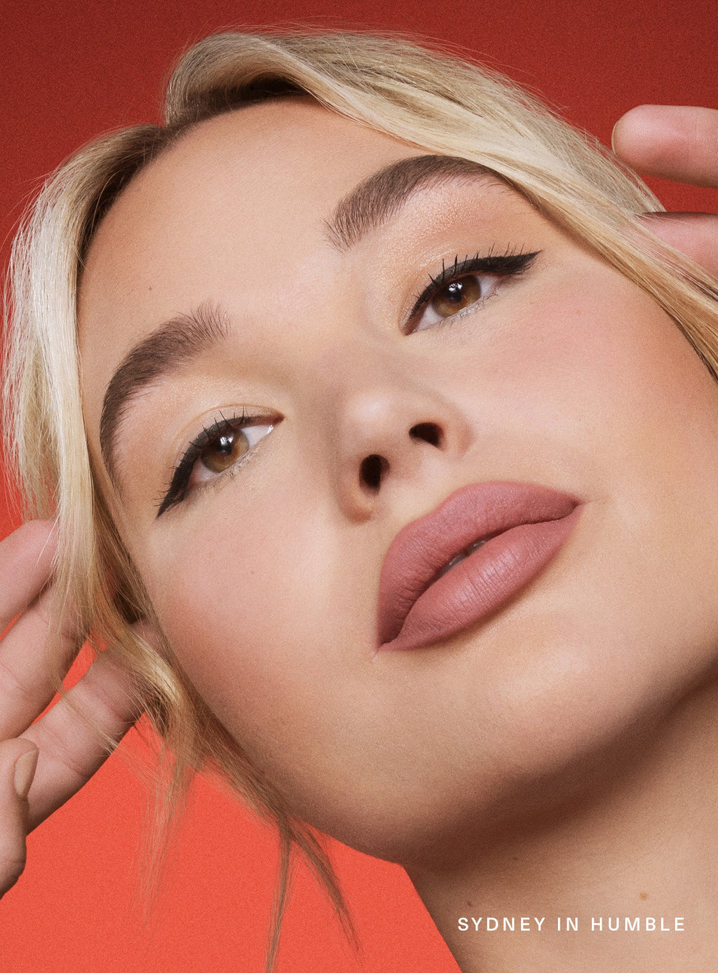Humble| Model Sydney wearing winged eyeliner looking confident wearing Rare Beauty's Kind Words Matte Lip Liner in the shade Humble.