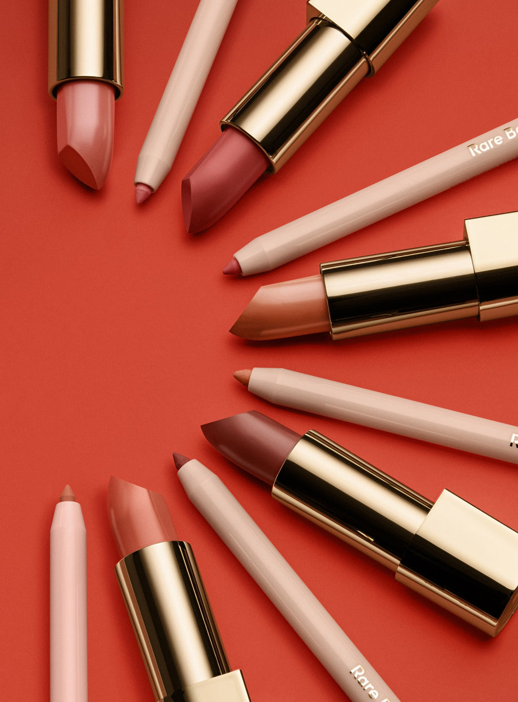 Five shades of Rare Beauty's Kind Words Matte Lip Liner and Kind Words Matte Lipstick arranged in a semi-circle. 