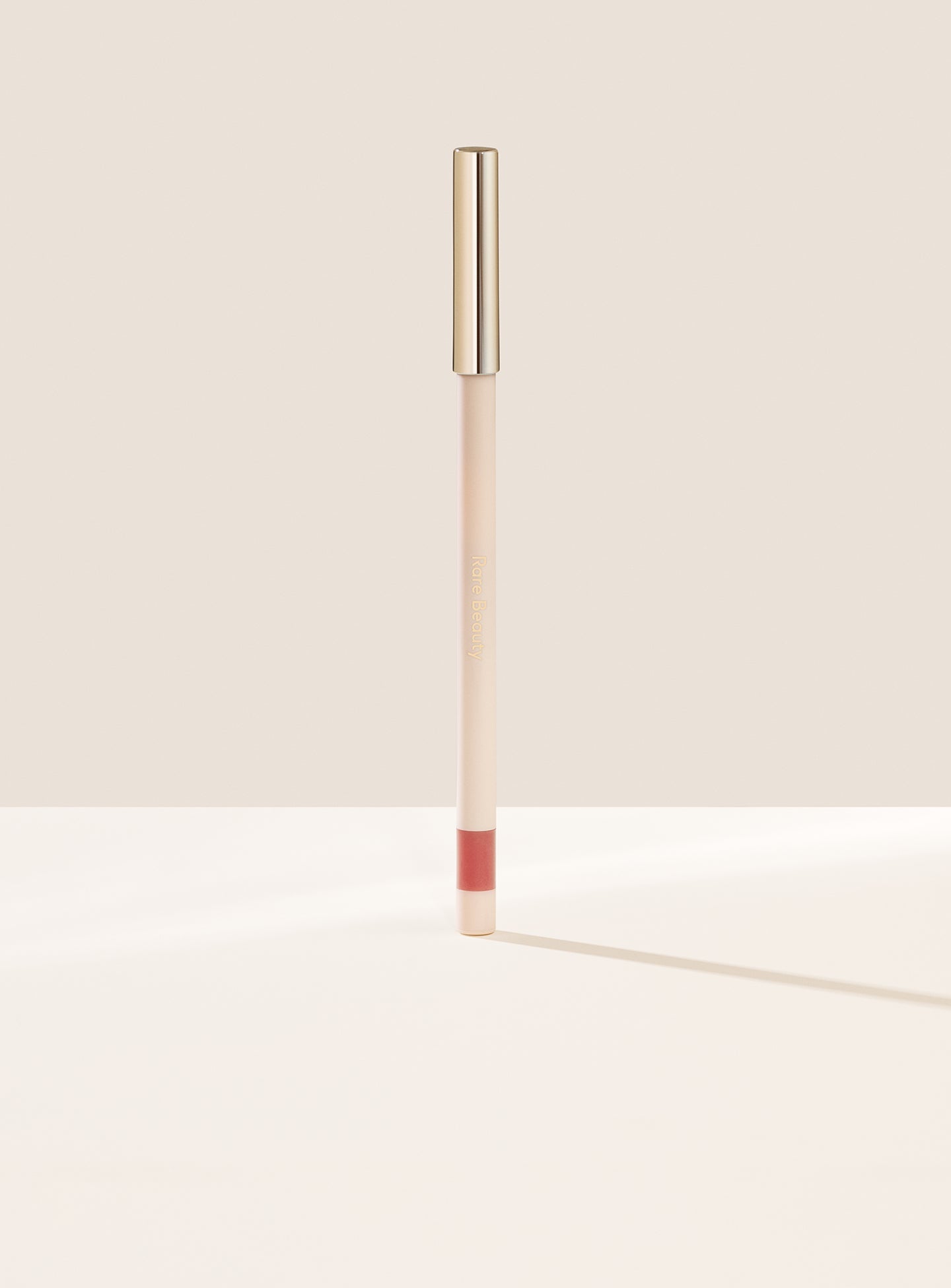 Lively| Rare Beauty's Kind Words Matte Lip Liner, a creamy waterproof lip liner in the shade Creative shown standing up with the cap on. 