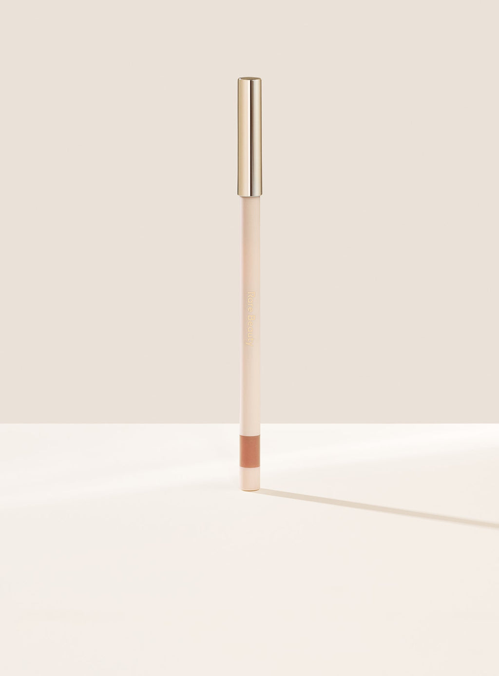 Talented| Rare Beauty's Kind Words Matte Lip Liner, a creamy waterproof lip liner in the shade Talented shown standing up with the cap on. 