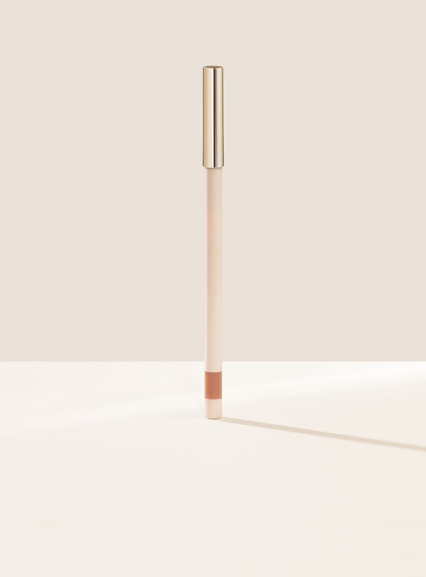 Talented| Rare Beauty's Kind Words Matte Lip Liner, a creamy waterproof lip liner in the shade Talented shown standing up with the cap on. 