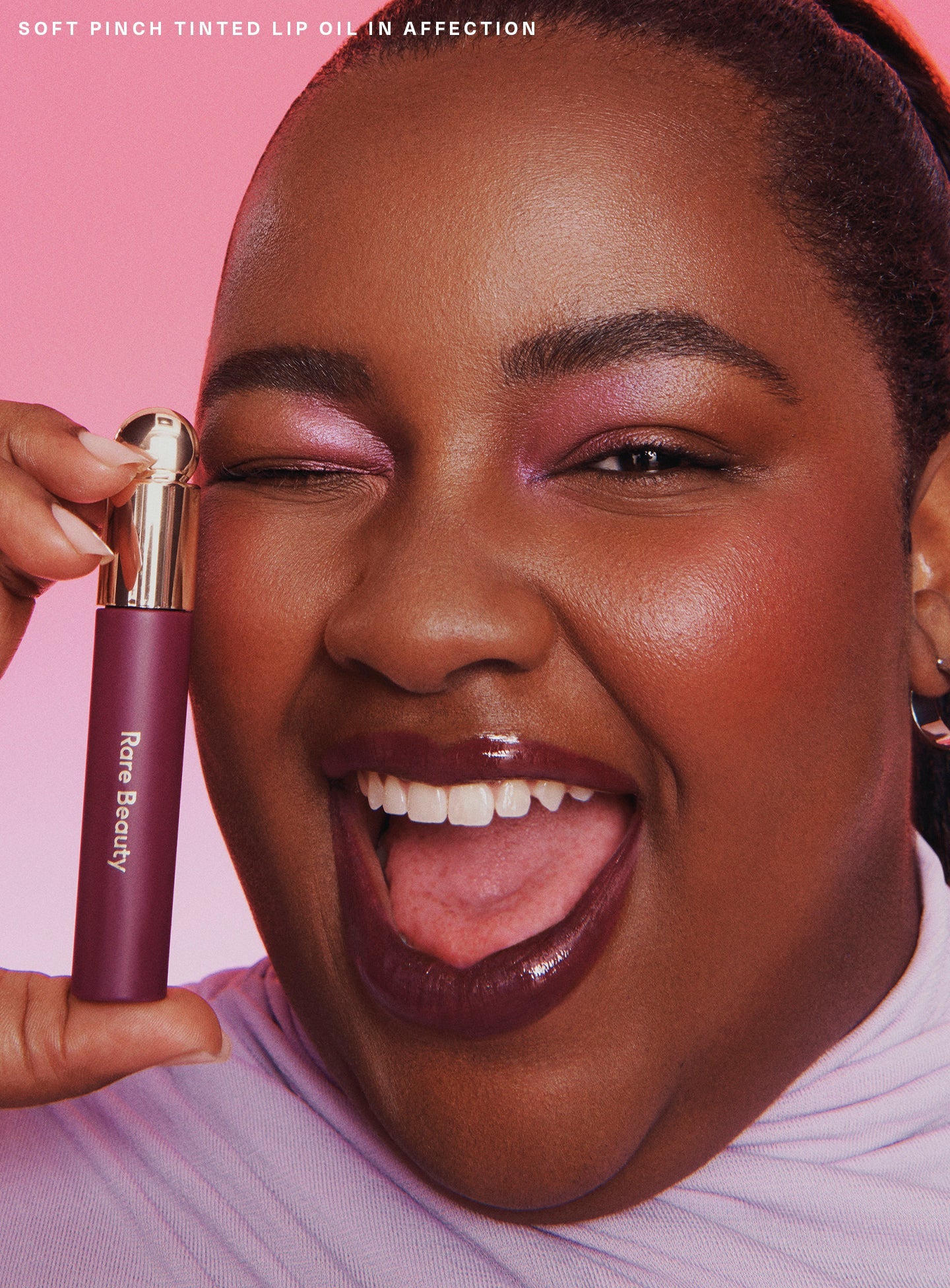 Affection| A model wearing Rare Beauty's Soft Pinch Lip Oil in shade "Affection".