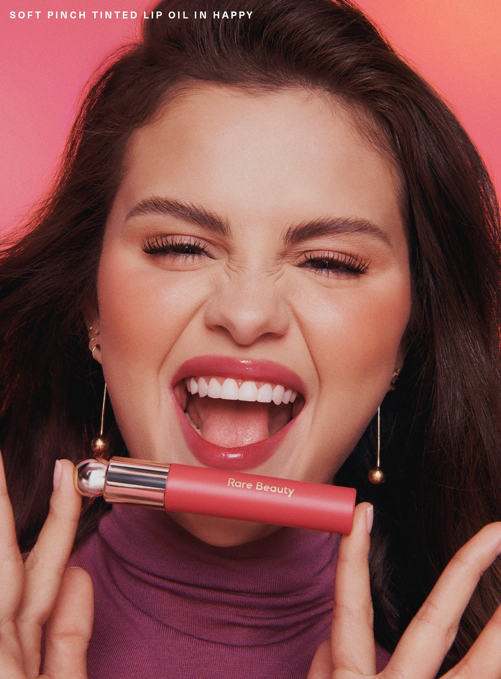 Happy| Selena Gomez holding Rare Beauty's Soft Pinch Tinted Lip Oil in shade " Happy".