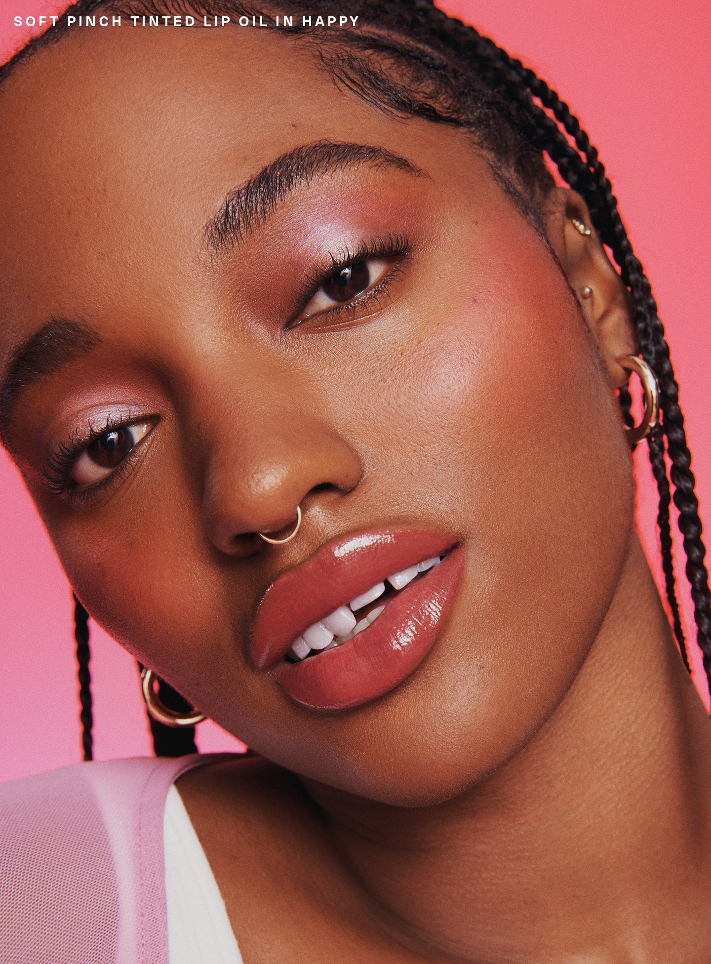 Happy| A model wearing Rare Beauty's Soft Pinch Tinted Lip Oil in shade "Happy".